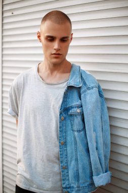 Metal bir çekim yakınındaki bir kot ceket ile şık yakışıklı adam