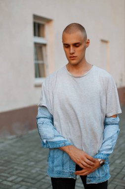 Yakışıklı genç bir gri gömlek ve sokakta bir kot ceket