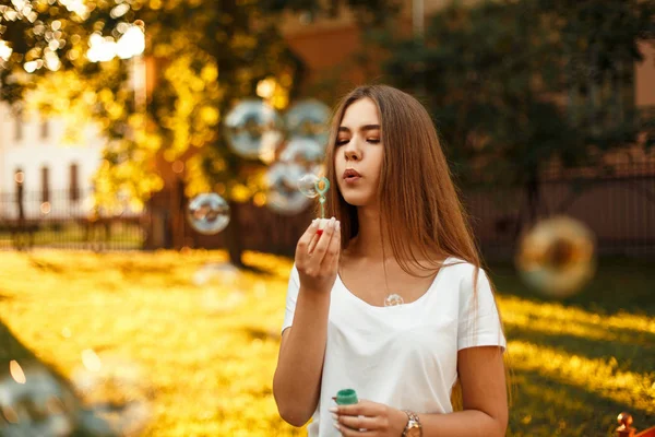 Femme heureuse soufflant des bulles de savon au coucher du soleil pendant les vacances d'été — Photo