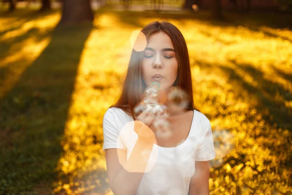 Feliz hermosa mujer soplando burbujas de jabón al atardecer en las vacaciones de verano — Foto de Stock