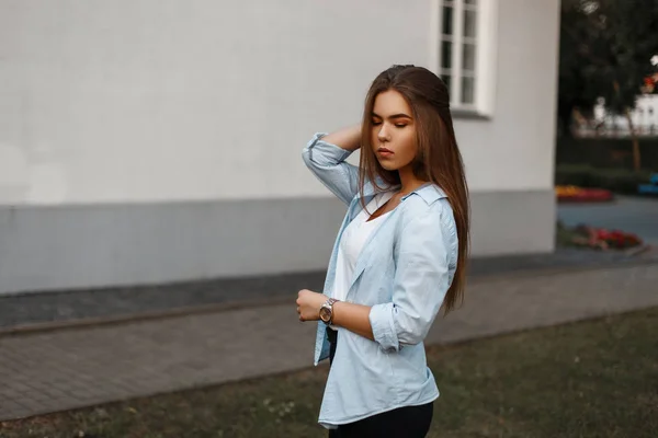 Hermosa joven con el pelo largo en ropa elegante verano posando cerca de la pared de la casa — Foto de Stock