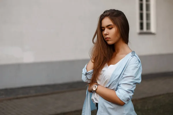 Hermosa chica modelo joven en un estilo de ropa casual de verano cerca de la pared de una casa — Foto de Stock