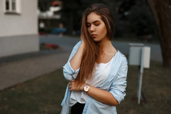 Hermosa joven de moda con cuidado de la piel con el pelo largo en una camisa azul y una camiseta blanca en un día de verano — Foto de Stock