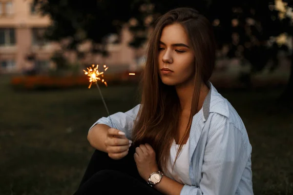 Hermosa joven con bengala chispeante fuego en la calle — Foto de Stock