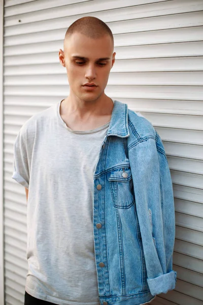 Metal bir çekim yakınındaki bir kot ceket ile şık yakışıklı adam
