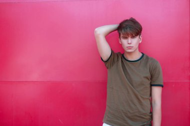 moda yakışıklı bir parlak pembe metal duvarının yakınında yeşil tişört içinde