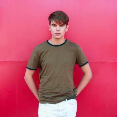 Pembe bir duvarının yakınında trendy kıyafetler yakışıklı genç adam