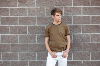 Şık genç yakışıklı bir T-shirt stand bir yaz gününde