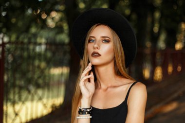 Siyah şık giysiler içinde makyaj ve moda şapka sokakta olan güzel kadın