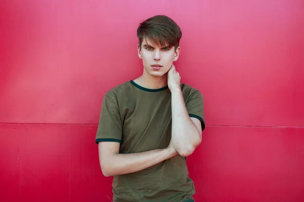 Joven guapo en ropa de verano de moda cerca de una pared de color rosa brillante — Foto de Stock