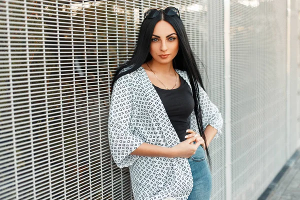 Bir kadının bir kılavuz duvarın yanında desenleri ile beyaz pelerinli moda güzel model