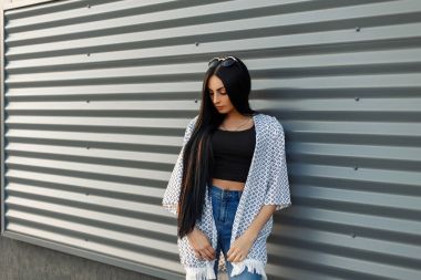 Metal duvarın yanında şık güzel gençlik giysili su kuyusu-damat uzun saçlı moda güzel kadın