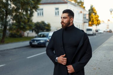 yakışıklı adam sakal ve saç modeli siyah şık paltolu sokakta yürüyor