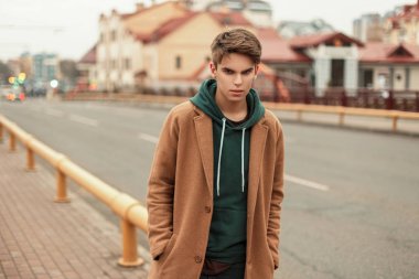 kapüşonlu ile şık bir ceket genç şık adam sokakta yürüyor