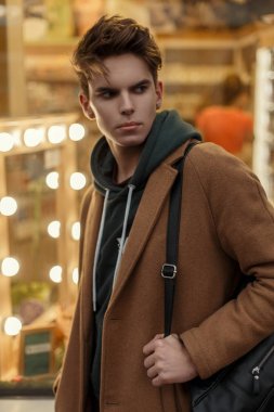  Şık yakışıklı genç trendy moda ceket ışıklar vitrin yakınındaki arka plan üzerinde şık bir çanta ile