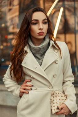 Şık şık kız güzel bir bej trendy ceket ve sokakta şık bir çanta