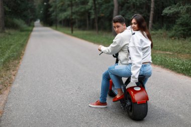 güzel genç çift kot ve beyaz kazak elektronik bir bisiklet