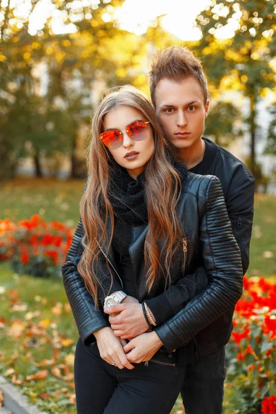 Mooie jong koppel in stijlvolle kleding met zonnebril in zonnige herfstdag in een park — Stockfoto