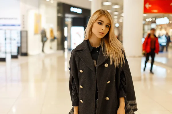 Belle femme élégante en manteau d'automne à la mode posant dans un centre commercial — Photo