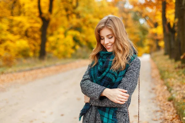 Schöne junge glückliche Frau in stylischem Mantel posiert im Herbst Park — Stockfoto