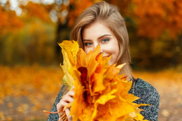 Glückliches Mädchen mit herbstgelben Blättern, das das Wetter genießt — Stockfoto