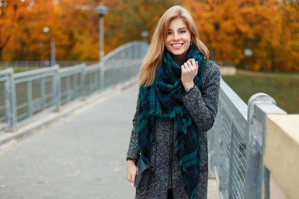 Ευτυχισμένη γυναίκα σε φθινόπωρο παλτό με μαντήλι βλέπουν φωτογραφική μηχανή στέκεται στο δρόμο — Φωτογραφία Αρχείου
