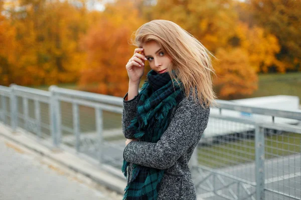 Mulher bonita em casaco de moda outono com cachecol no dia de outono perto da ponte — Fotografia de Stock