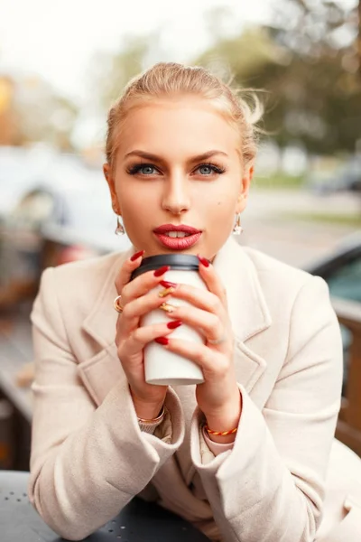Detail portrét krásné ženy s kávou v stylovém kabátě na ulici — Stock fotografie