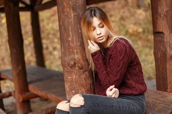 木造のロッジにセーターで美しいアメリカ モデルの女の子が座っています。 — ストック写真