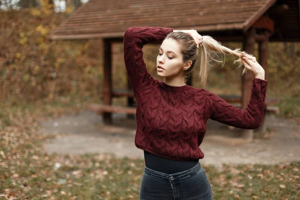 Vintage örme kazak sonbahar günü bir ahşap pergola yakınındaki şık genç kız
