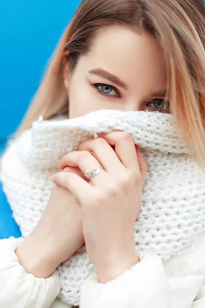 Portret de aproape a unei tinere fete frumoase cu ochi albaștri cu eșarfă tricotată elegantă albă în jachetă de iarnă — Fotografie, imagine de stoc