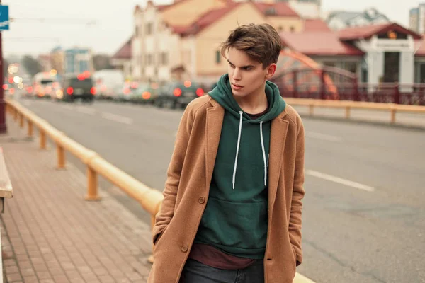 Apuesto joven con estilo en un abrigo vintage de moda paseos en la ciudad — Foto de Stock