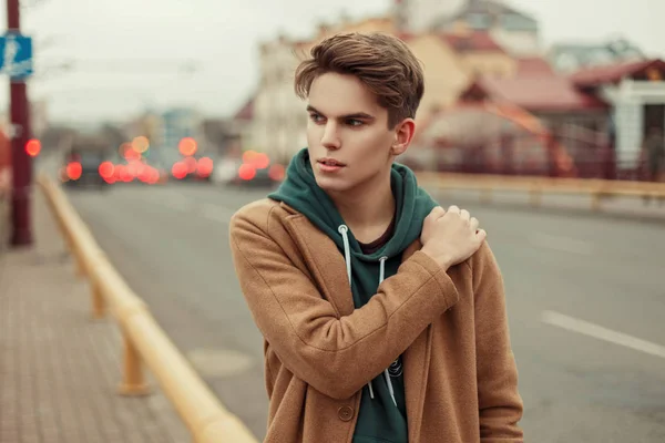 Joven con estilo en un abrigo vintage de moda con capucha en la calle — Foto de Stock
