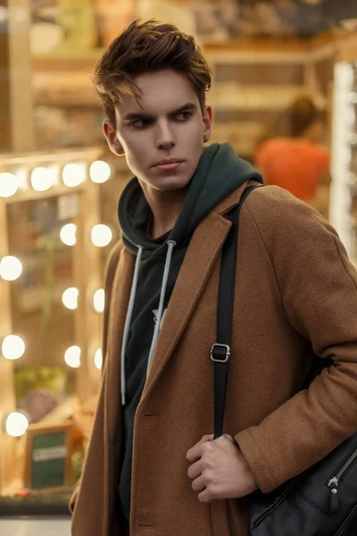  Şık yakışıklı genç trendy moda ceket ışıklar vitrin yakınındaki arka plan üzerinde şık bir çanta ile