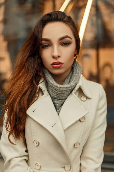 Beautiful stylish young brunette girl in trendy coat posing outdoors — Stock Photo, Image
