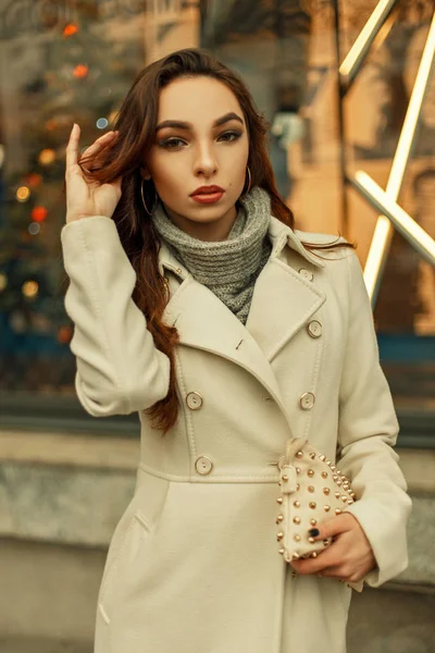 Belle femme à la mode dans un manteau d'automne à la mode avec un sac élégant posant en plein air dans la ville — Photo