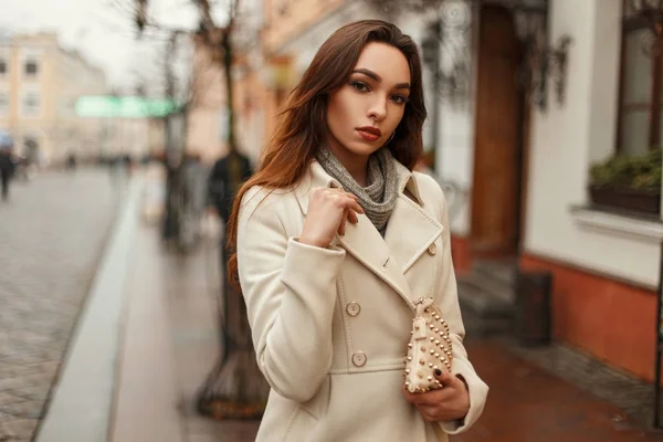 Jeune fille élégante dans un manteau à la mode avec un sac de mode dans la ville — Photo