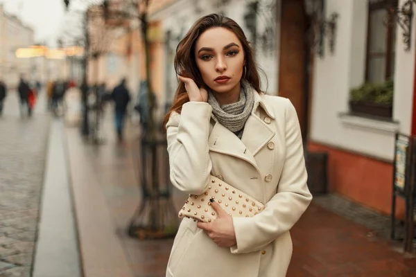 美丽的年轻女子在时髦的大衣与时尚袋在城市 — 图库照片