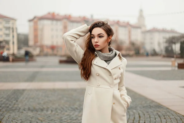 Mujer joven hermosa de moda en abrigo de moda posando en la ciudad en un día de otoño —  Fotos de Stock