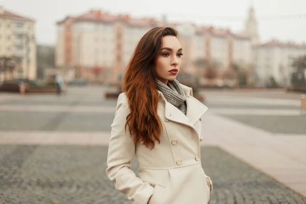 Sexy joven mujer en un abrigo de otoño de moda con un suéter posando en la ciudad — Foto de Stock