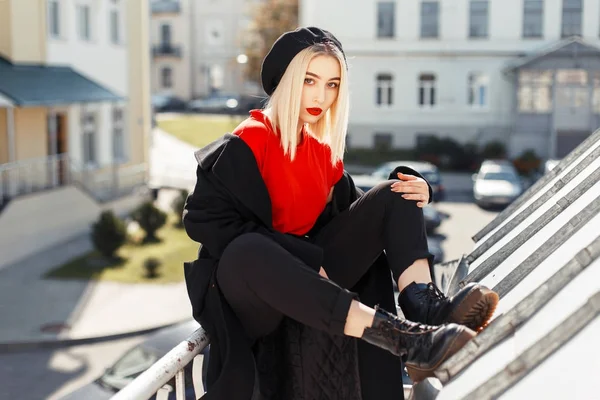 Mulher na moda bonita em um casaco preto de outono na moda em um dia ensolarado — Fotografia de Stock