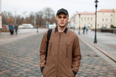 yakışıklı genç bir siyah kap ile moda paltolu adam ve wa çanta