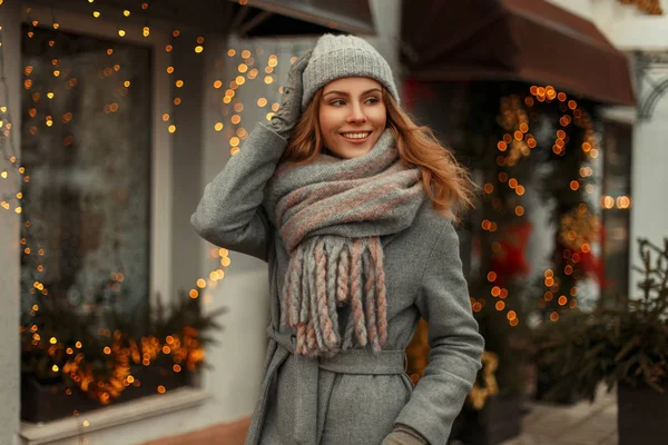 Jovem mulher bonita feliz em um casaco cinza na moda com uma moda — Fotografia de Stock