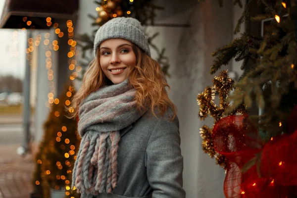 Gelukkig mooie jonge vrouw in een grijze vintage jas met een knitte — Stockfoto