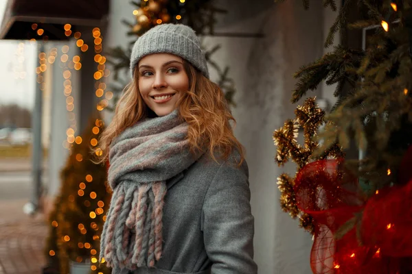 Glücklich schöne junge Frau in einem grauen Vintage-Mantel mit einem Strick — Stockfoto