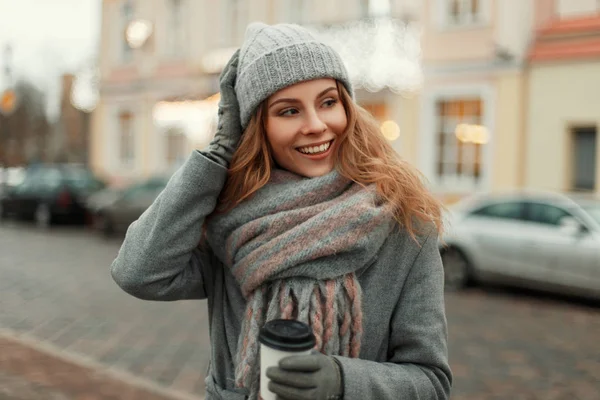 Счастливая молодая женщина с улыбкой в сером винтажном пальто с кни — стоковое фото