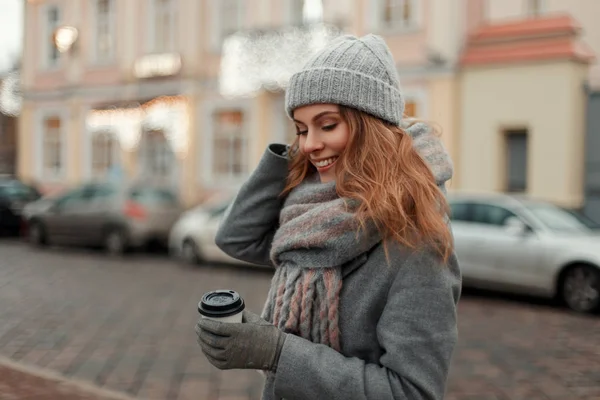 Mujer hermosa feliz en un abrigo de moda con un tejido elegante ha — Foto de Stock