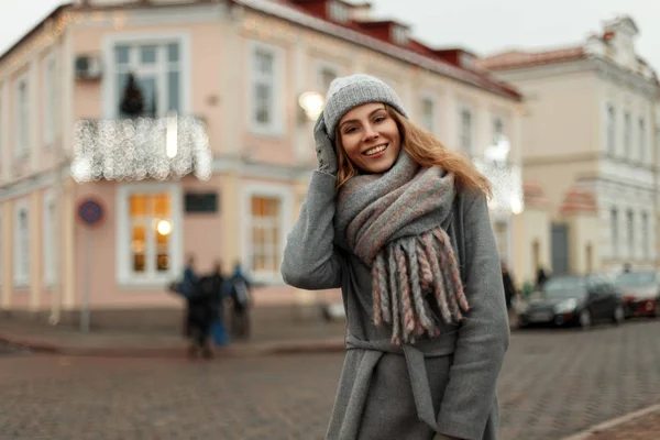 Счастливая веселая молодая женщина с улыбкой в модном пальто с хлевом — стоковое фото