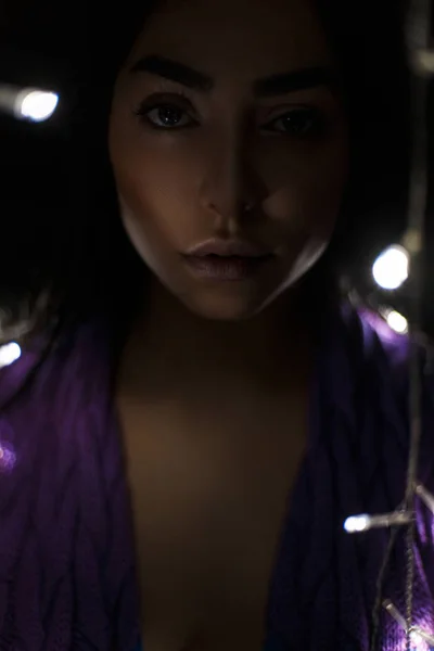 Dunkles Porträt einer schönen jungen Frau mit Lichtern — Stockfoto