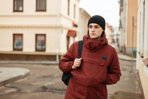 Hombre joven guapo en una chaqueta deportiva de moda con una bolsa y — Foto de Stock